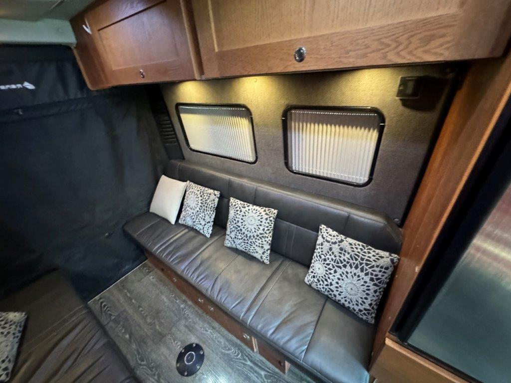  and bench seating.|RV rental kitchen features a sleek black microwave oven — photo 14