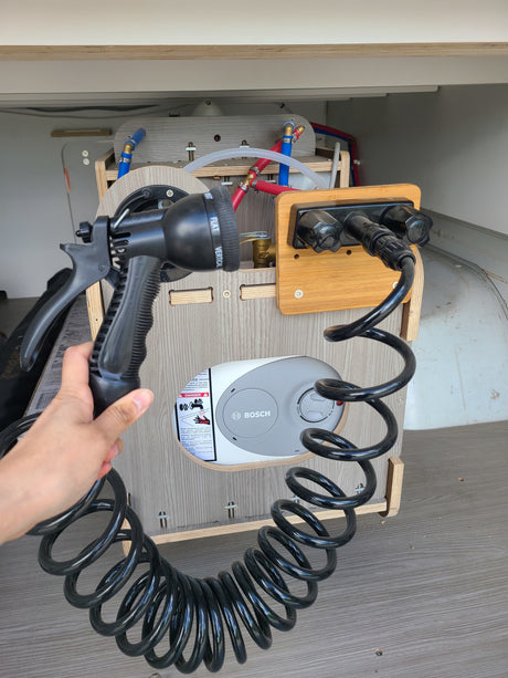 RV rental outdoor shower setup with Bosch water heater and coiled hose. Perfect for campervan adventures.
