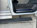 RV rental side entry featuring an illuminated 'EXPLORER' door sill and a sturdy running board for easy access.