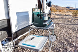 Outdoor kitchen setup next to an RV rental: portable stove, pot, and cutting board in a desert camp. Enjoy cooking!