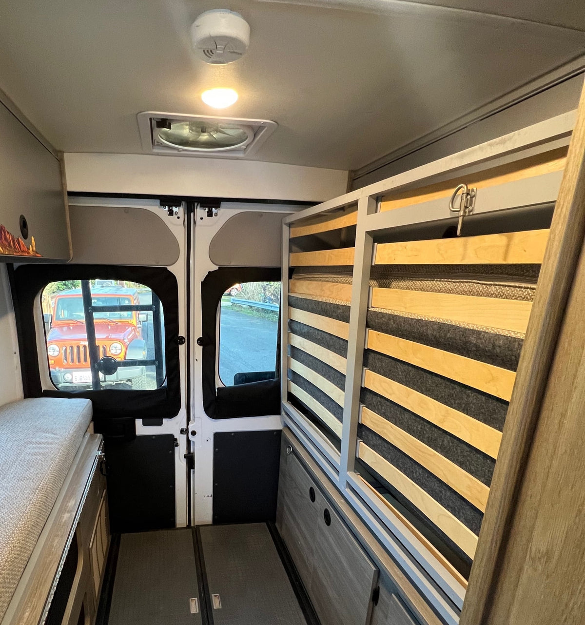  and a fire extinguisher.|Inside an **rv rental**: light-colored rear seating and dinette — photo 11