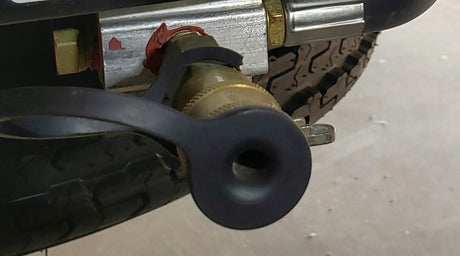 This RV rental image shows a tire with aggressive tread, and a brass valve fitting with a black protective cap on the chassis.