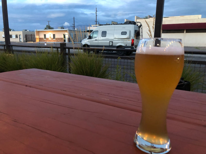  functional kitchen.|Golden beer on a wooden table. A white RV rental van drives on the street — photo 6