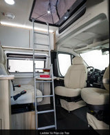 RV rental interior: Ladder to pop-up top. This cozy camper van features light seating, windows & overhead storage.
