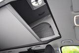 Inside an RV rental: a bright pop-top roof with a fan, mesh window, and retractable shade for ventilation and comfort.