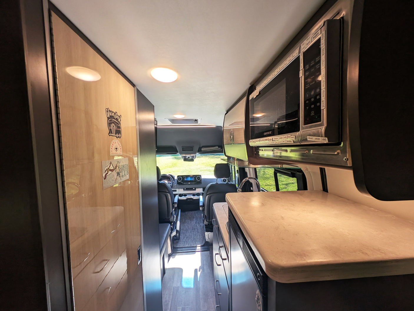 Inside this **rv rental**, a compact kitchen with a microwave and counter is visible, leading to the front cabin for road trip adventures.