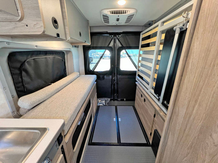  with open doors & pop-top extended at sunset.|Cozy RV rental interior with a comfortable bed