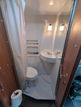 Compact RV rental wet bath with toilet, sink, and shower. Ideal for travel.