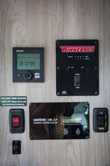 RV rental utility panel: Truma, Winnebago, and Xantrex solar controls manage heating, tanks, and battery status.