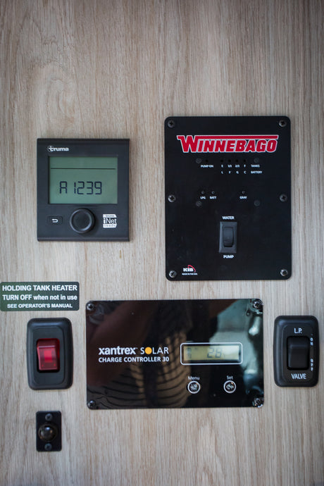 RV rental utility panel: Truma, Winnebago, and Xantrex solar controls manage heating, tanks, and battery status.