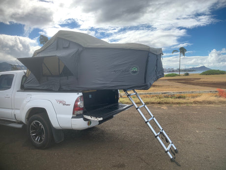  great for an rv rental trip.|RV rental ready: White Toyota Tacoma with a deployed Nomadic rooftop tent for overlanding or camping adventures.|An RV rental for overland adventure: truck with rooftop tent
