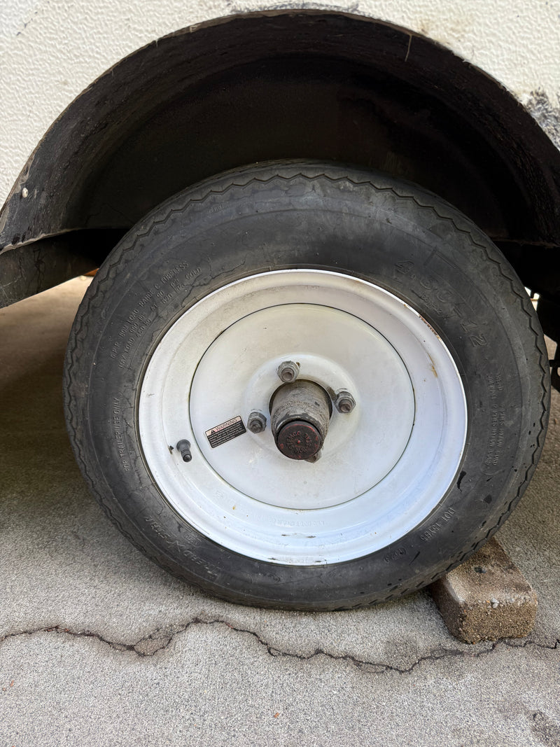 Worn 4.80-12 trailer tire and white wheel, possibly from an RV rental unit. Displays "FOR TRAILER USE ONLY" label. — photo 15