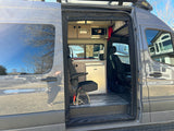 Step inside this RV rental camper van: kitchenette with microwave & fridge, swivel seat, and solar power setup.