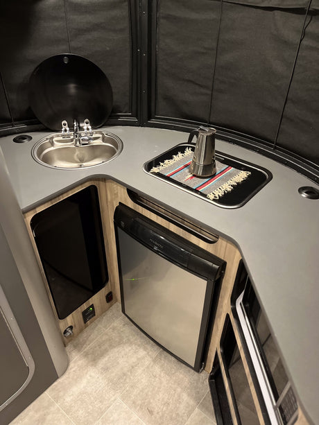 RV rental kitchen: stainless sink, compact Dometic fridge, and cooking area with a moka pot. Great for travel!