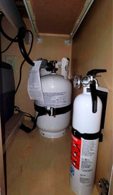 RV rental safety: Propane tank and fire extinguisher secured in a cabinet, alongside electrical components.