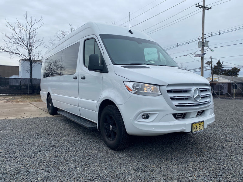 Modern white Mercedes-Benz Sprinter rv rental van with black wheels, parked on gravel in New Jersey, ready for adventure. — photo 2