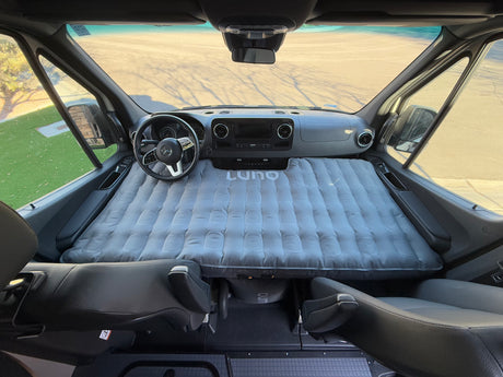 Experience comfort in this RV rental! A Luno air mattress transforms the front cabin of this camper van for sleeping.