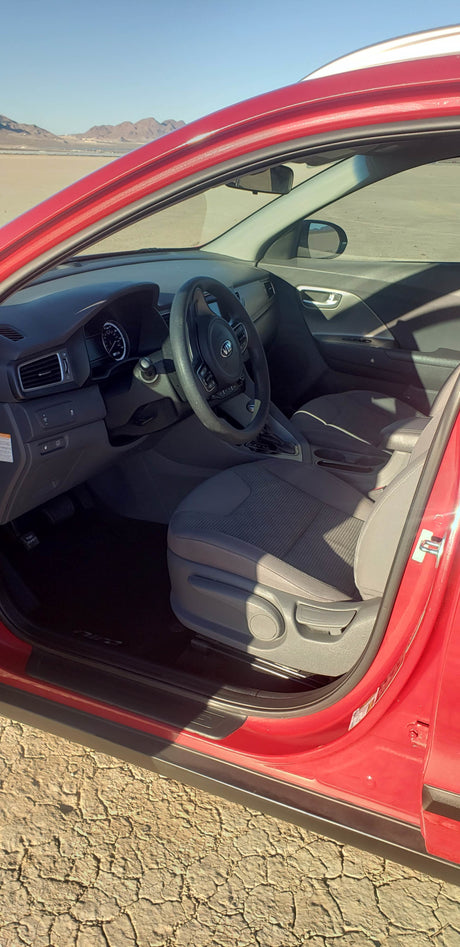 Inside a red car, perfect for a desert road trip, potentially part of an rv rental journey. Mountains in view.
