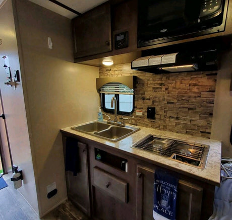 This RV rental's compact kitchen offers a double sink, stovetop, and microwave for on-the-go cooking.