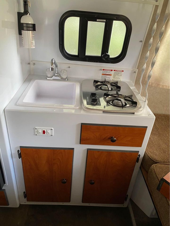  ready for outdoor adventure.|Compact RV rental kitchenette featuring a sink
