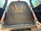 RV rental van's rear is open, featuring a dark fabric screen with mesh. An internal fan and lights are visible, set for camping.