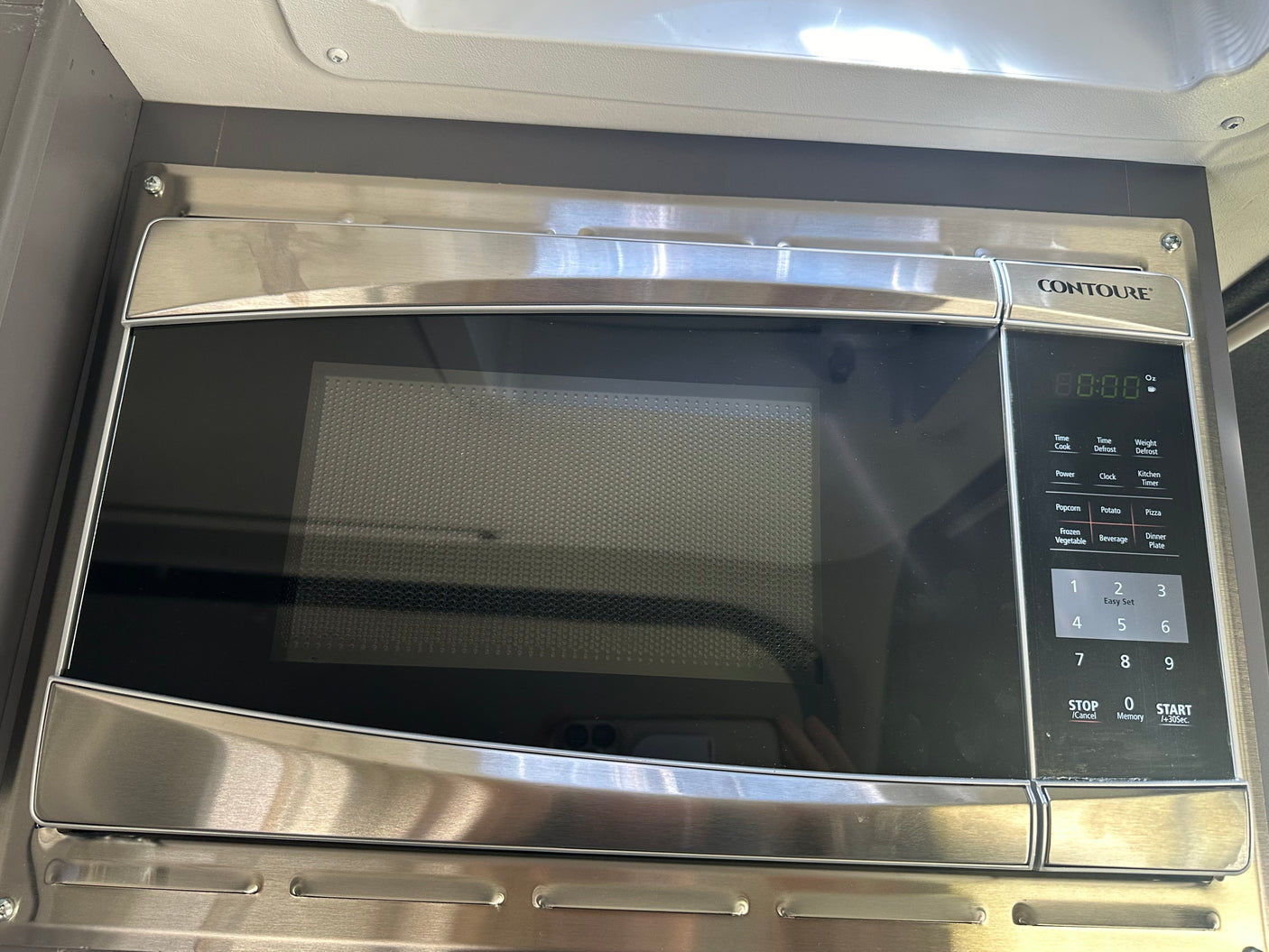 Stainless steel CONTOURE microwave, perfect for an RV rental. Features a digital display and touch control panel for cooking.