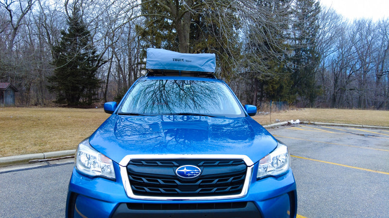 This blue Subaru Forester with a Thule Tepui roof-top tent offers a compact RV rental experience for outdoor adventures. — photo 9