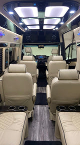 Luxurious RV rental interior features cream leather seats, wood floor, and ambient lighting for a premium travel experience.