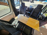 RV rental interior with front and rear seating, plus a versatile wooden table, ideal for dining or work.