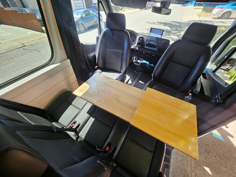 RV rental interior with front and rear seating, plus a versatile wooden table, ideal for dining or work. — photo 7