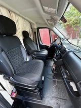 Inside this RV rental: front cabin with quilted seats, dashboard, and patterned privacy curtains.