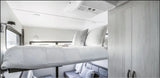 Compact RV rental interior featuring a clever drop-down bed, comfy lower seating, and built-in storage.