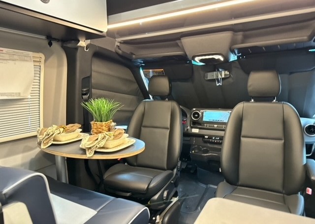  offers comfortable outdoor living.|Exploring the desert: An RV rental van with bikes is parked before majestic red rock cliffs under a brilliant blue sky.|RV rental camper van parked on a dark beach at sunset. Its lights glow — photo 5
