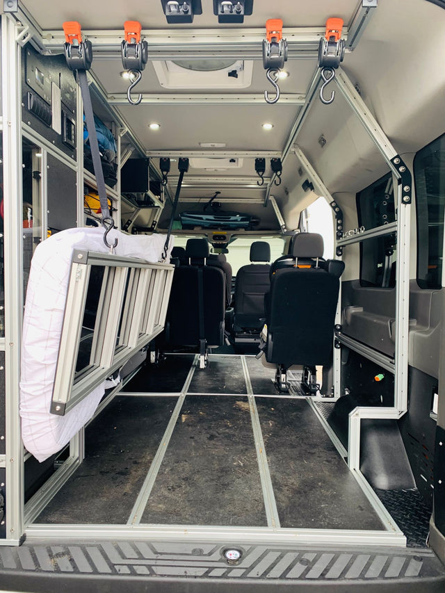  parked on gravel.|Spacious RV rental interior featuring a large overhead TV and child safety seat