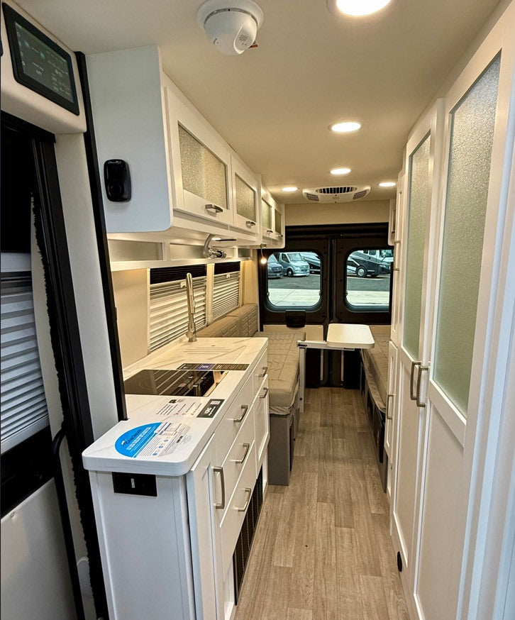 RV rental interior: Modern kitchenette, comfy seating, and smart storage define this compact camper van living space.