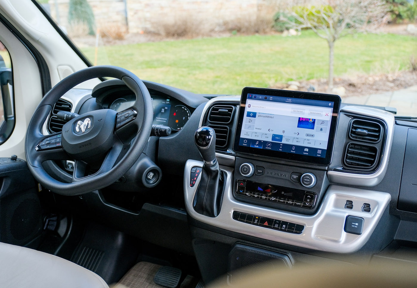 Spacious RV rental cabin with large infotainment screen, RAM steering wheel, and modern climate controls for comfortable travel. — photo 10