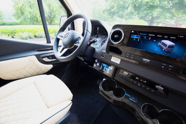  side door open to show premium cream interior.|Luxury RV rental interior: Mercedes-Benz dashboard with large screen