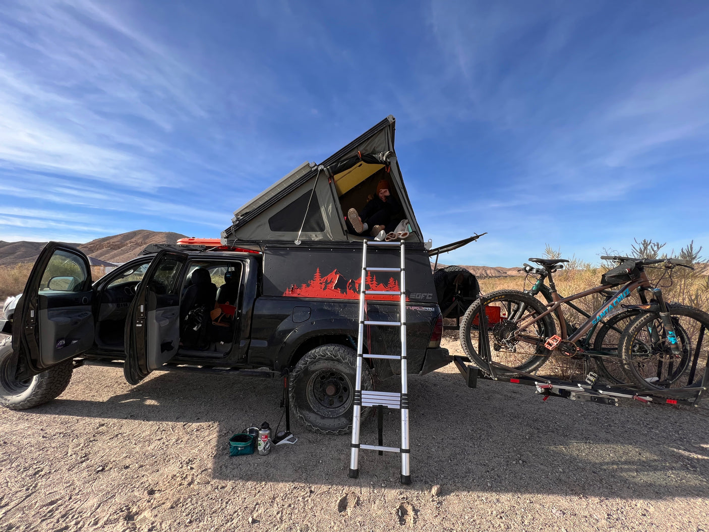 Explore the desert in this custom overlanding truck with rooftop tent & bikes. Ideal **RV rental** for adventure!
