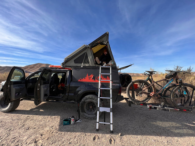Explore the desert in this custom overlanding truck with rooftop tent & bikes. Ideal **RV rental** for adventure!