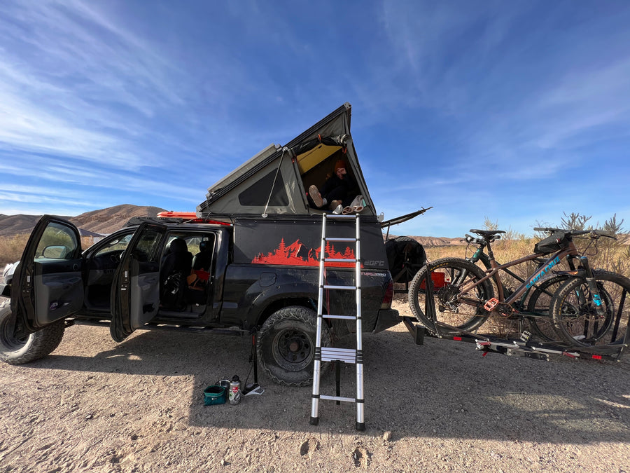Explore the desert in this custom overlanding truck with rooftop tent & bikes. Ideal **RV rental** for adventure!