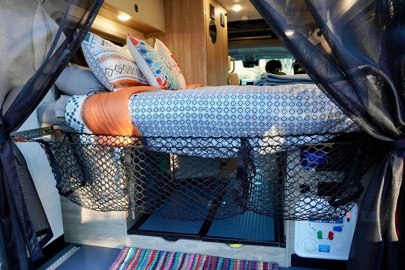 Experience comfort in this RV rental! A cozy bed, mesh storage, and accessible utilities optimize space for travel.