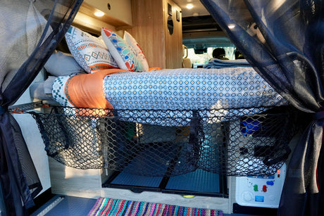 Experience comfort in this RV rental! A cozy bed, mesh storage, and accessible utilities optimize space for travel.