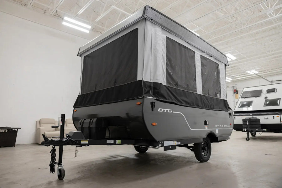 This gray and black pop-up RV rental, seen extended indoors, is perfect for your next camping or travel adventure.