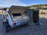 Overland rv rental: RockyTrax teardrop camper with rear galley, rooftop shower, and side tent ready for adventure.
