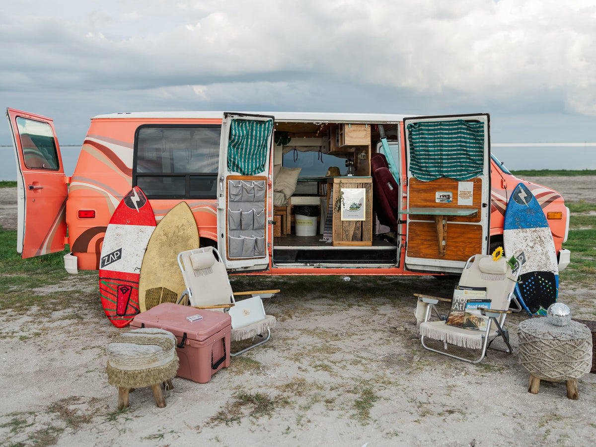 Relaxed beach setup: vintage RV rental van with open doors