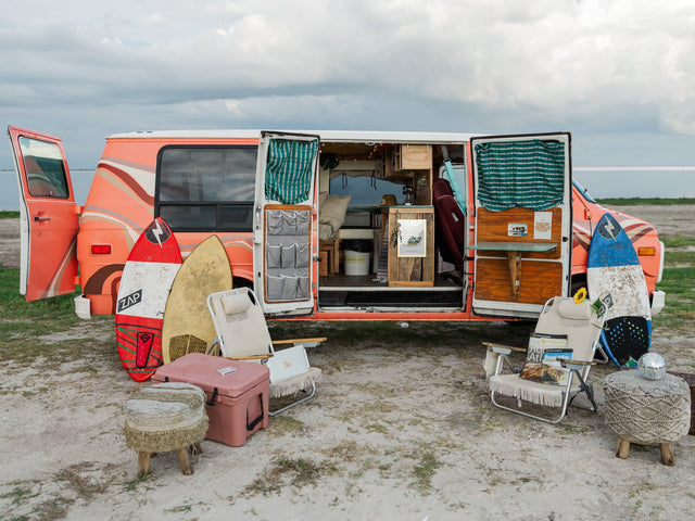 Relaxed beach setup: vintage RV rental van with open doors