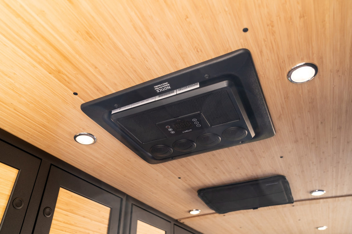 Inside an RV rental: AVELIT AC unit with digital display and vents on a bamboo ceiling with LED lights, ensuring comfortable air conditioning. — photo 11