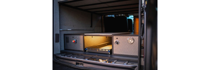  and a pull-out kitchen/gear tray for travel.|RV rental van's rear: modular storage system