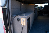 RV rental's rear utility area with a connected hose, shower nozzle, and water controls on gray fabric walls.