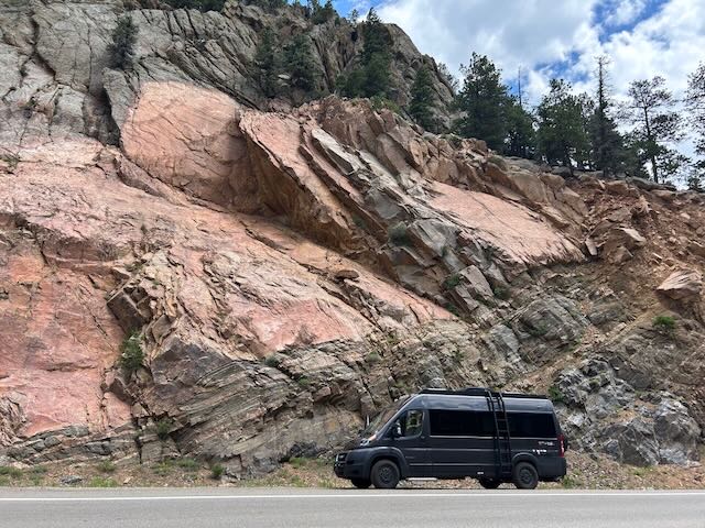 Black RV rental parked roadside next to stunning